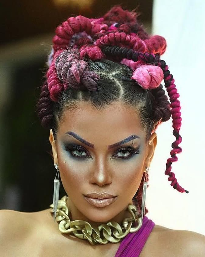 Mulher com tranças afro em tons de rosa e roxo