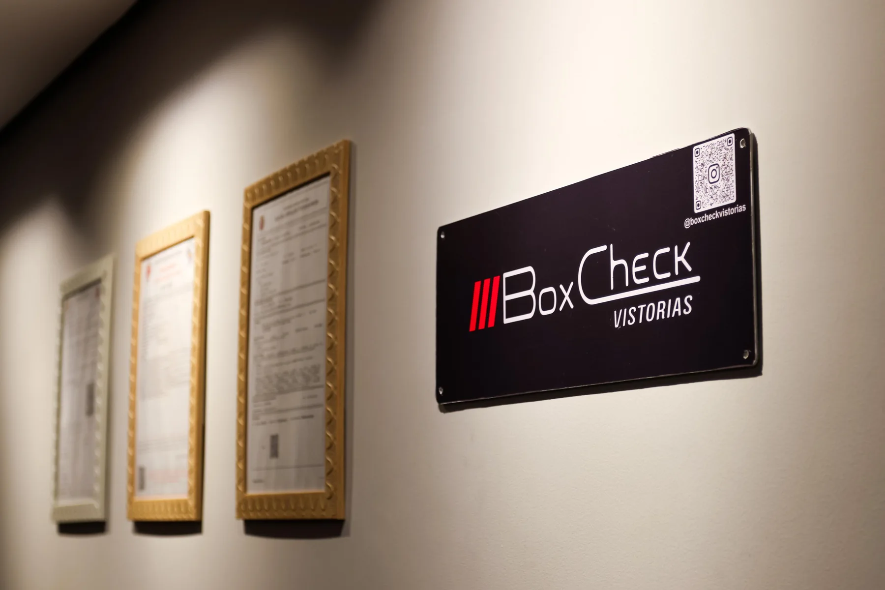 Identificação BoxCheck Vistorias na parede da unidade